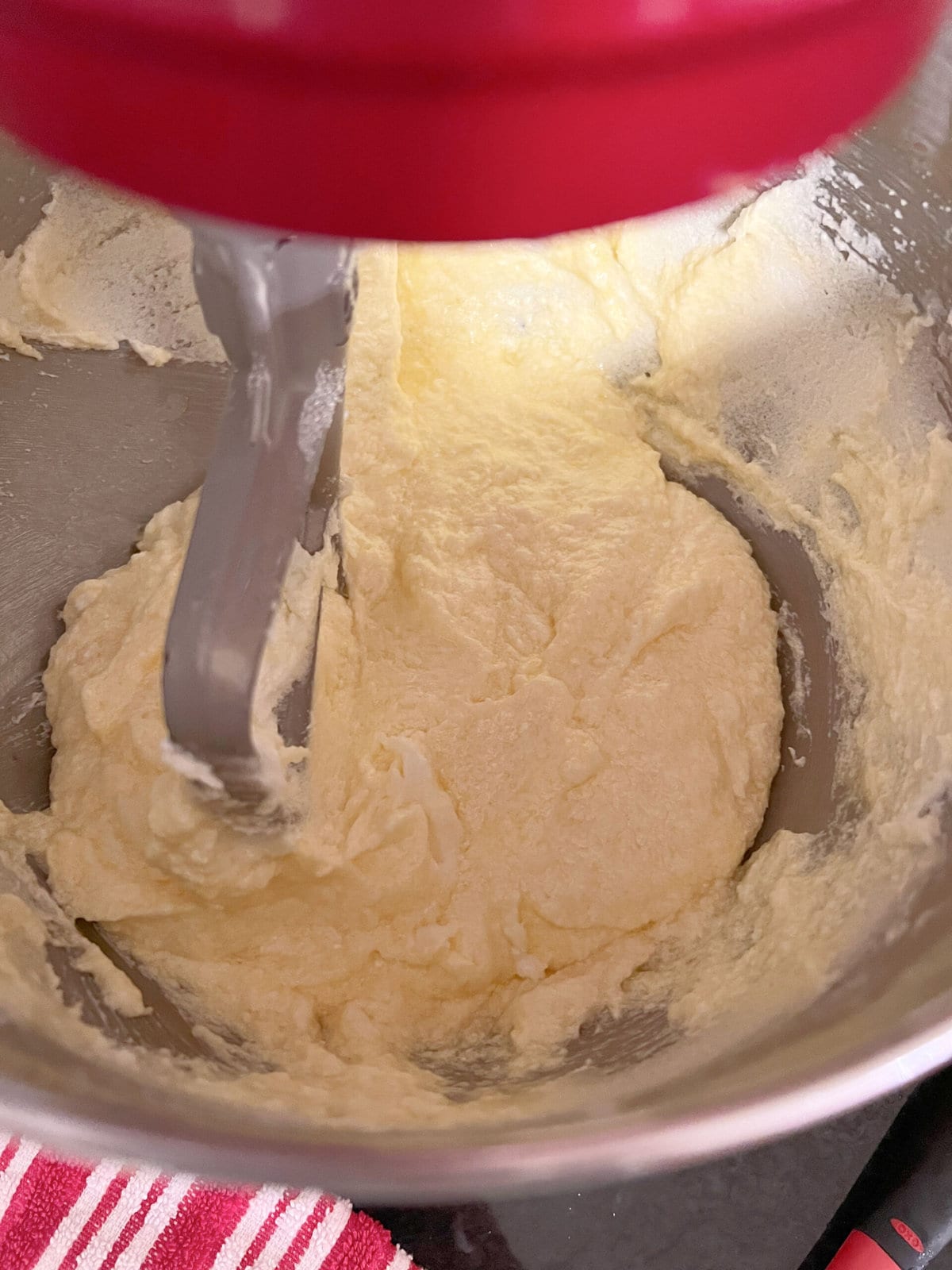 Adding eggs to pound cake batter in mixing bowl.