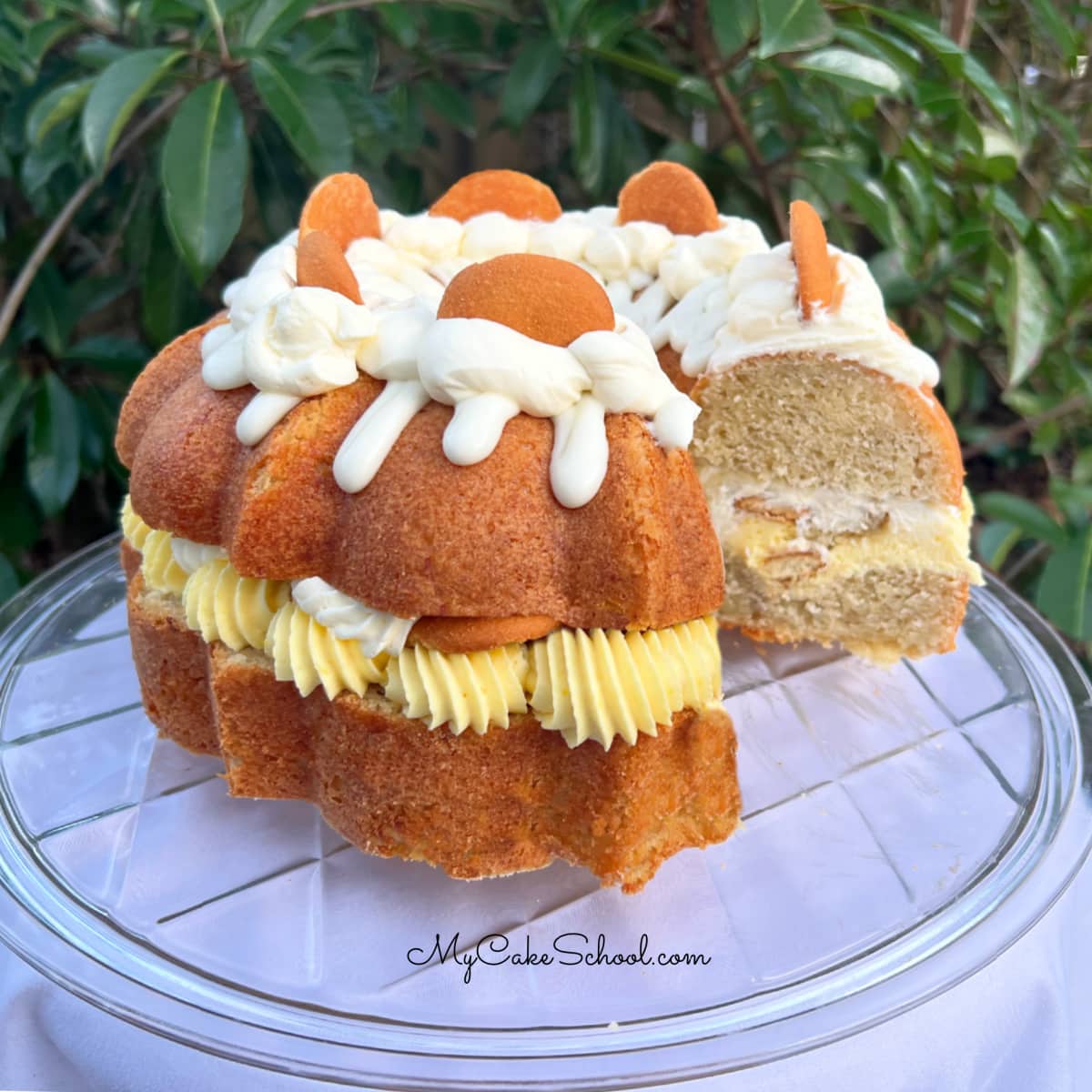 Banana Pudding Cake, sliced, on a pedestal.