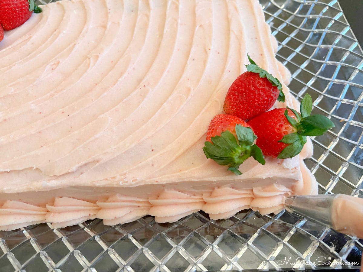 Adding a shell border around the base of the sheet cake.