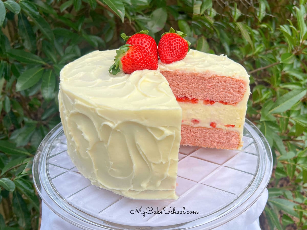 Sliced Strawberry Cheesecake Cake on a cake pedestal.