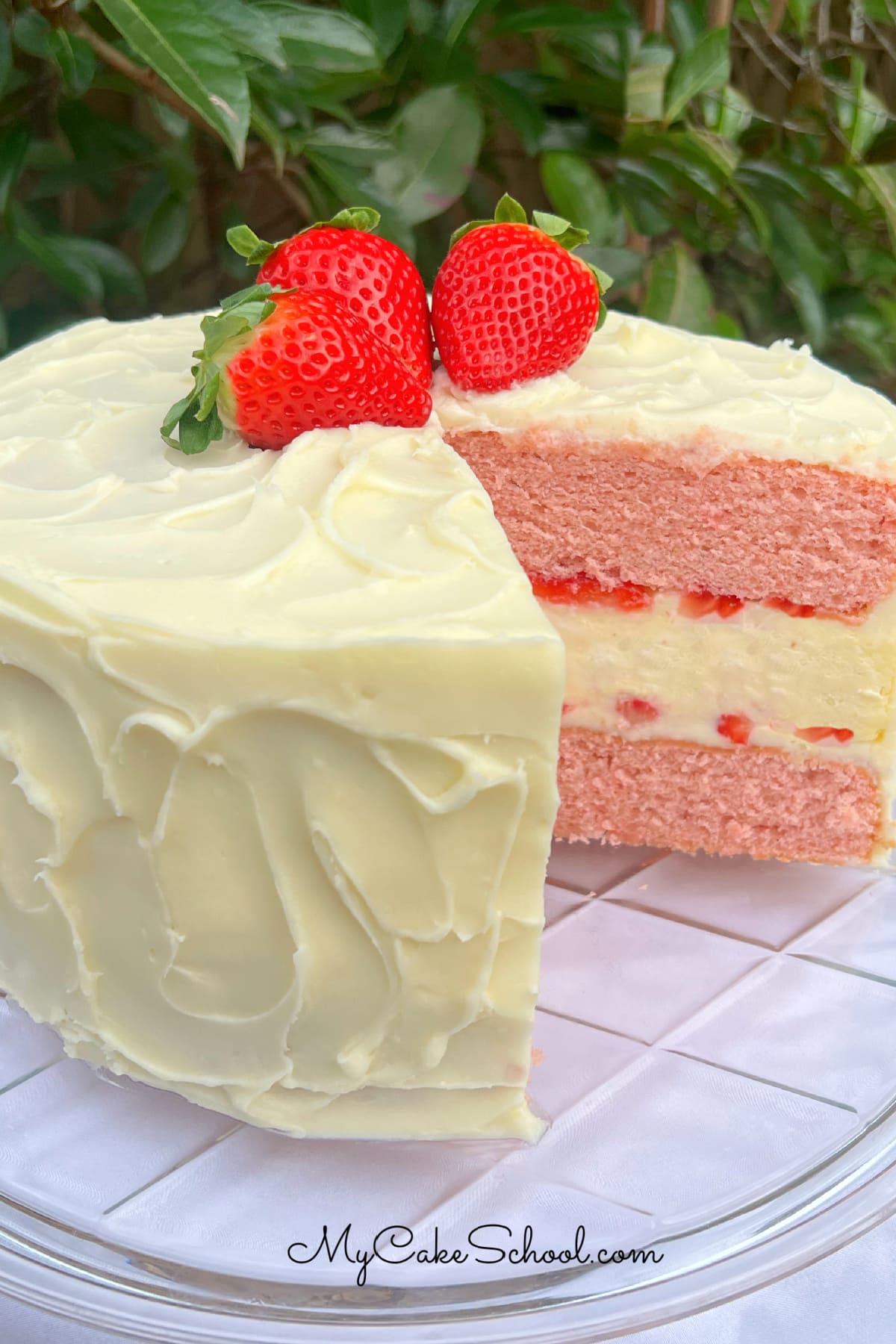 Sliced Strawberry Cheesecake cake on a pedestal.