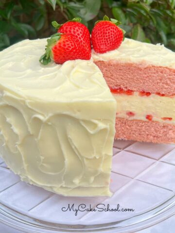 Sliced Strawberry Cheesecake Cake on a cake pedestal.