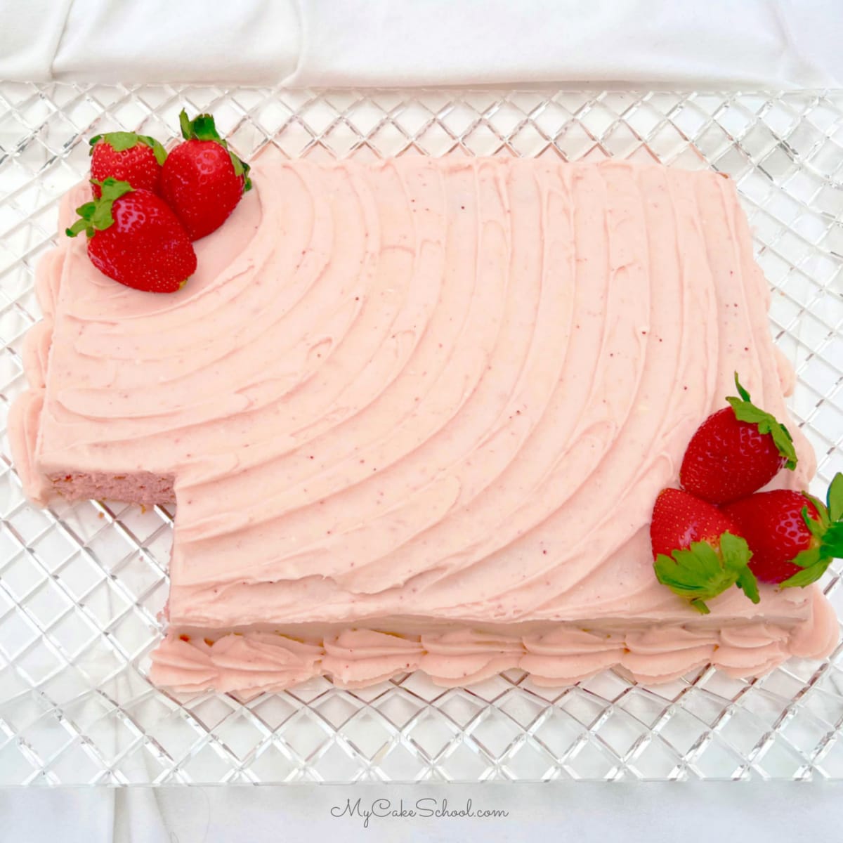 Strawberry Sheet Cake, sliced, on a cake platter.