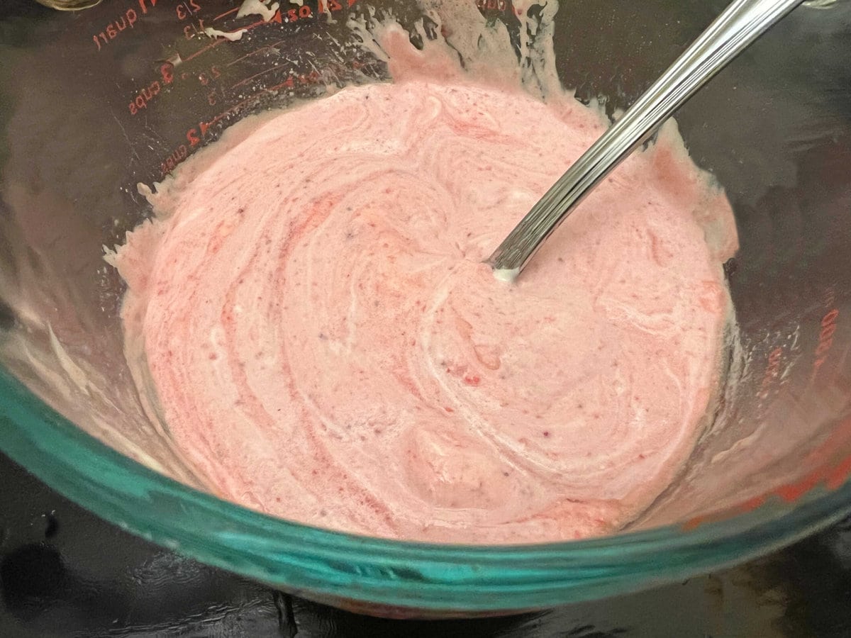 Wet ingredients for strawberry sour cream cake, in glass bowl.