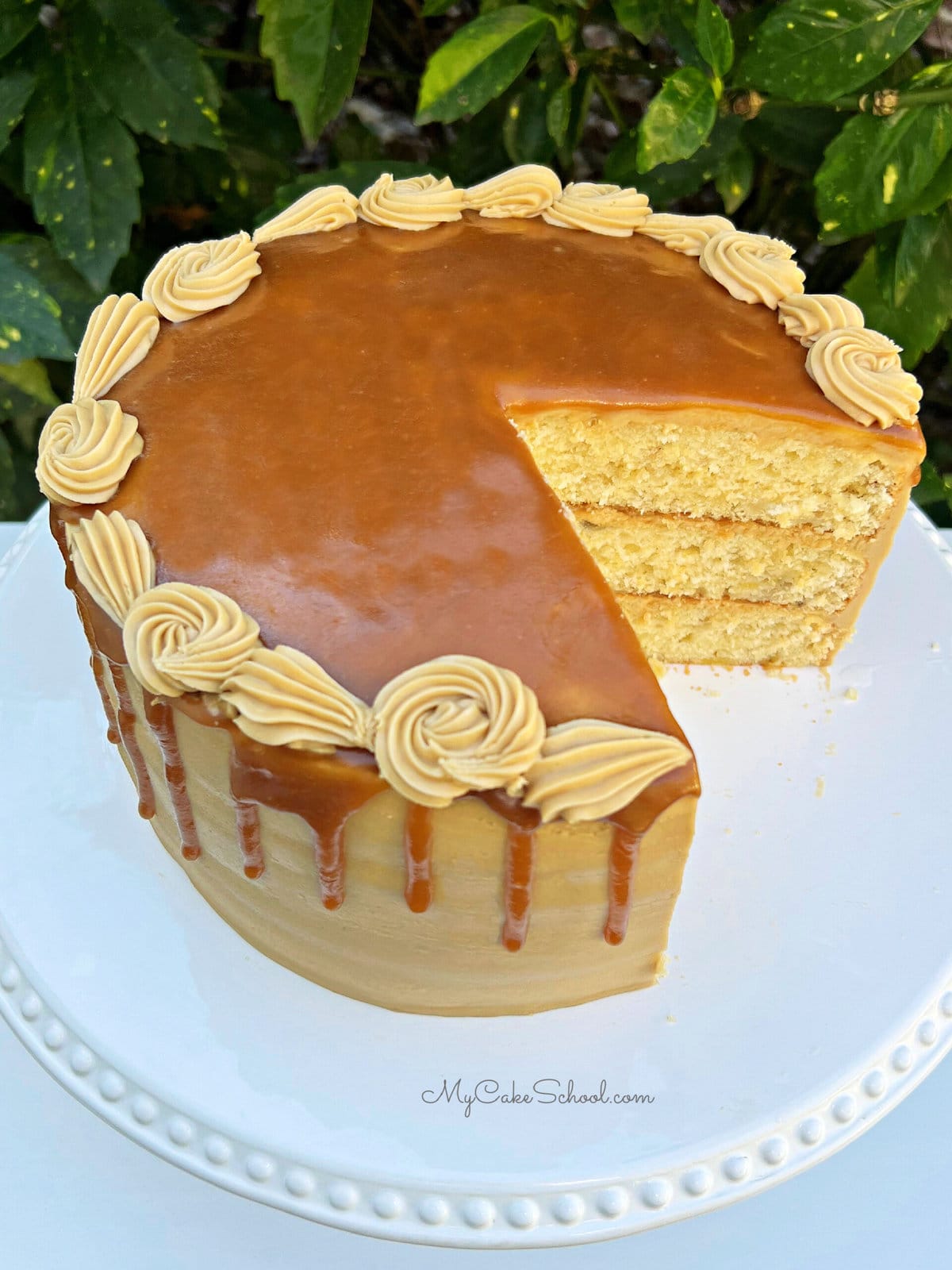 Banana Caramel Cake, sliced, on a cake pedestal.