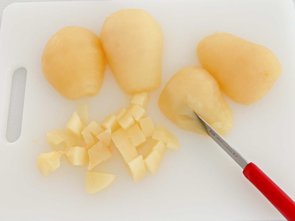 Sliced pears on a cutting board with a knife.