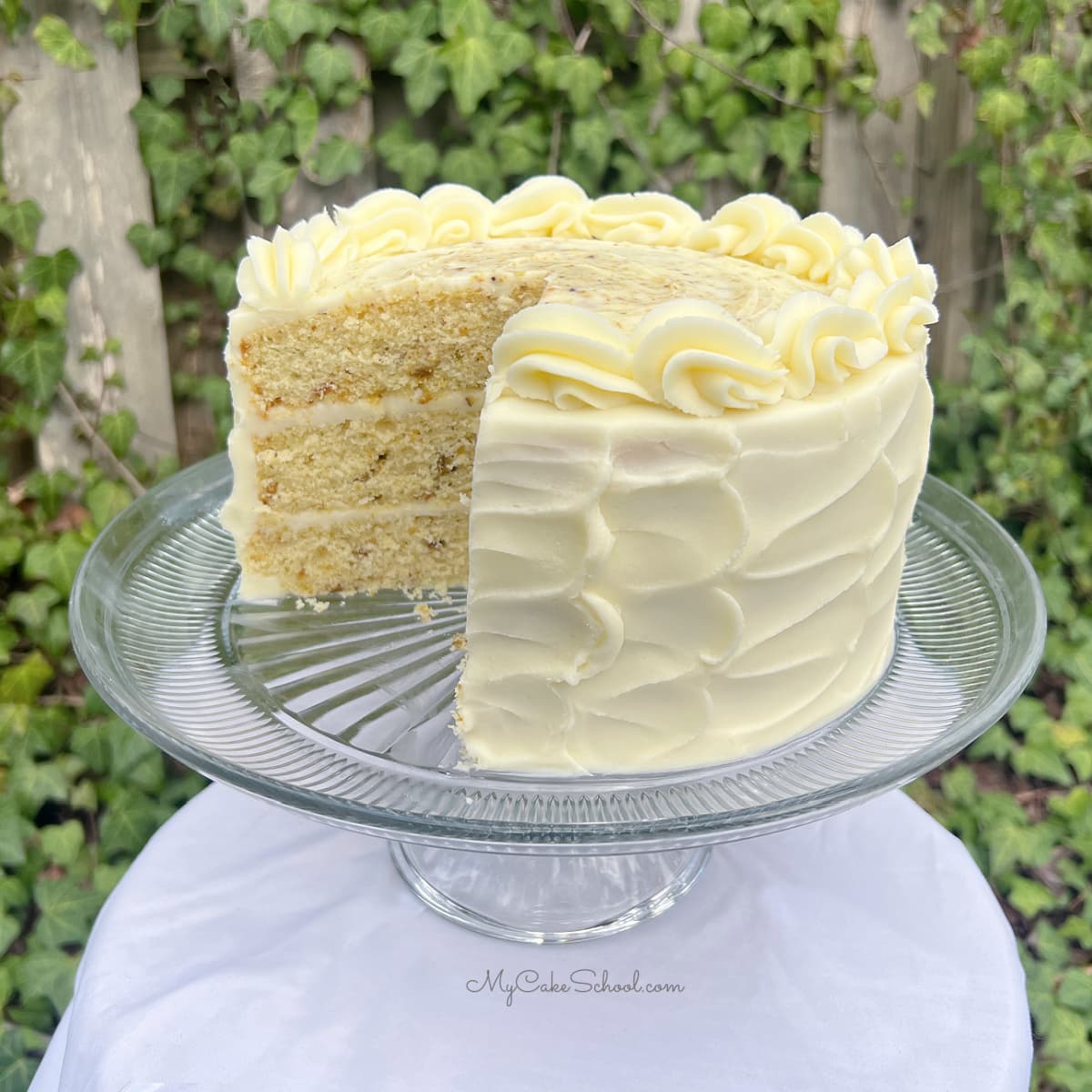 Pistachio Cake, sliced, on a cake pedestal.