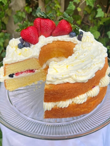 Lemon Berry Cake, sliced, on a cake pedestal.