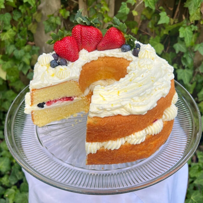 Lemon Berry Cake, sliced, on a cake pedestal.