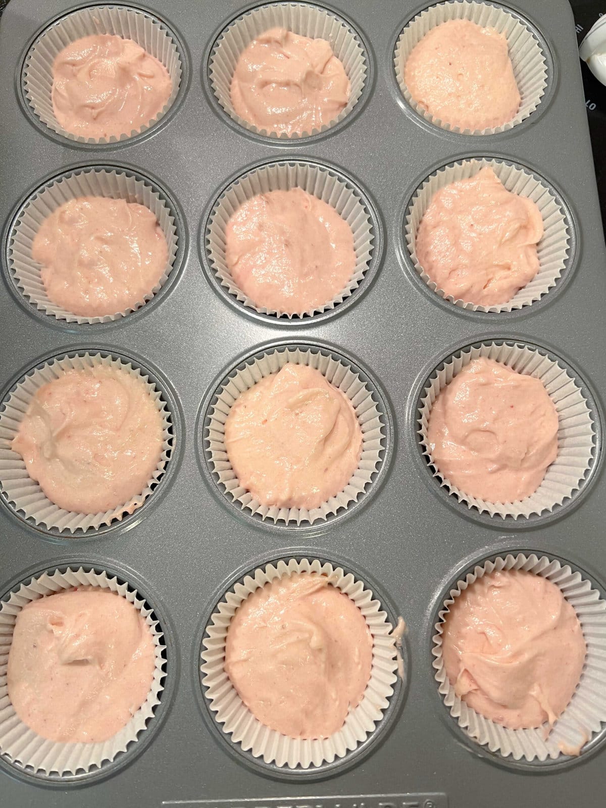 Strawberry cupcake batter in the cupcake liners.