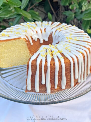 Lemon Ricotta Cake, sliced, on a cake pedestal.