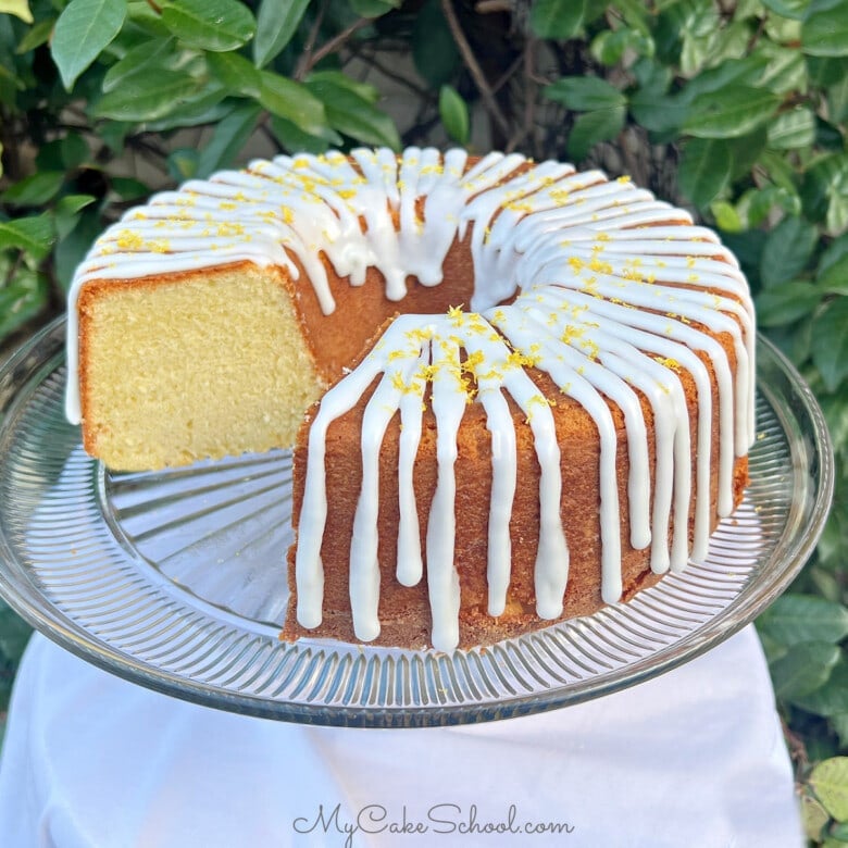 Lemon Ricotta Cake, sliced, on a cake pedestal.