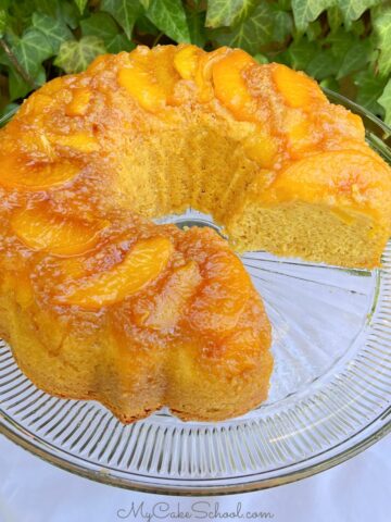 Peach Upside Down Cake, sliced, on a cake pedestal.