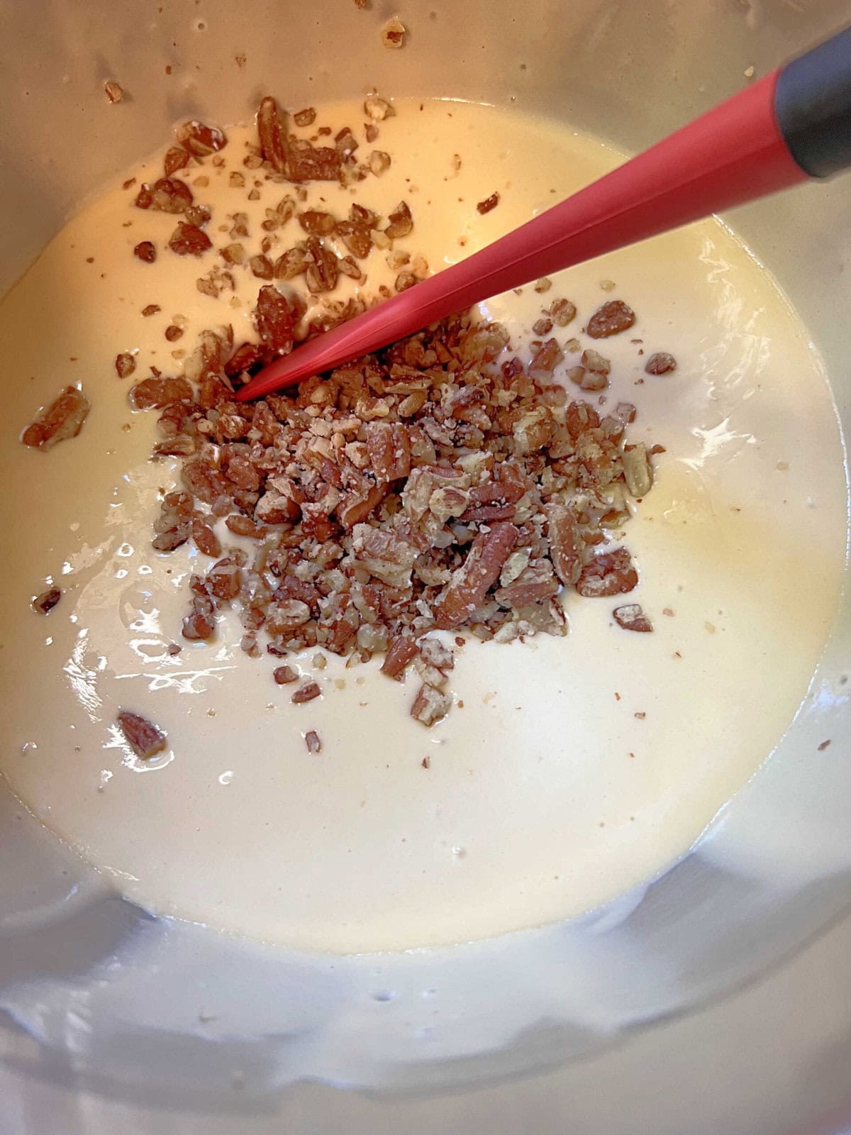 Stirring butter pecans into cake batter.