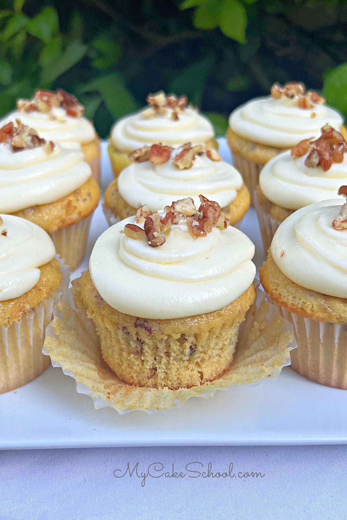 Butter pecan cupcakes on a cake platter.