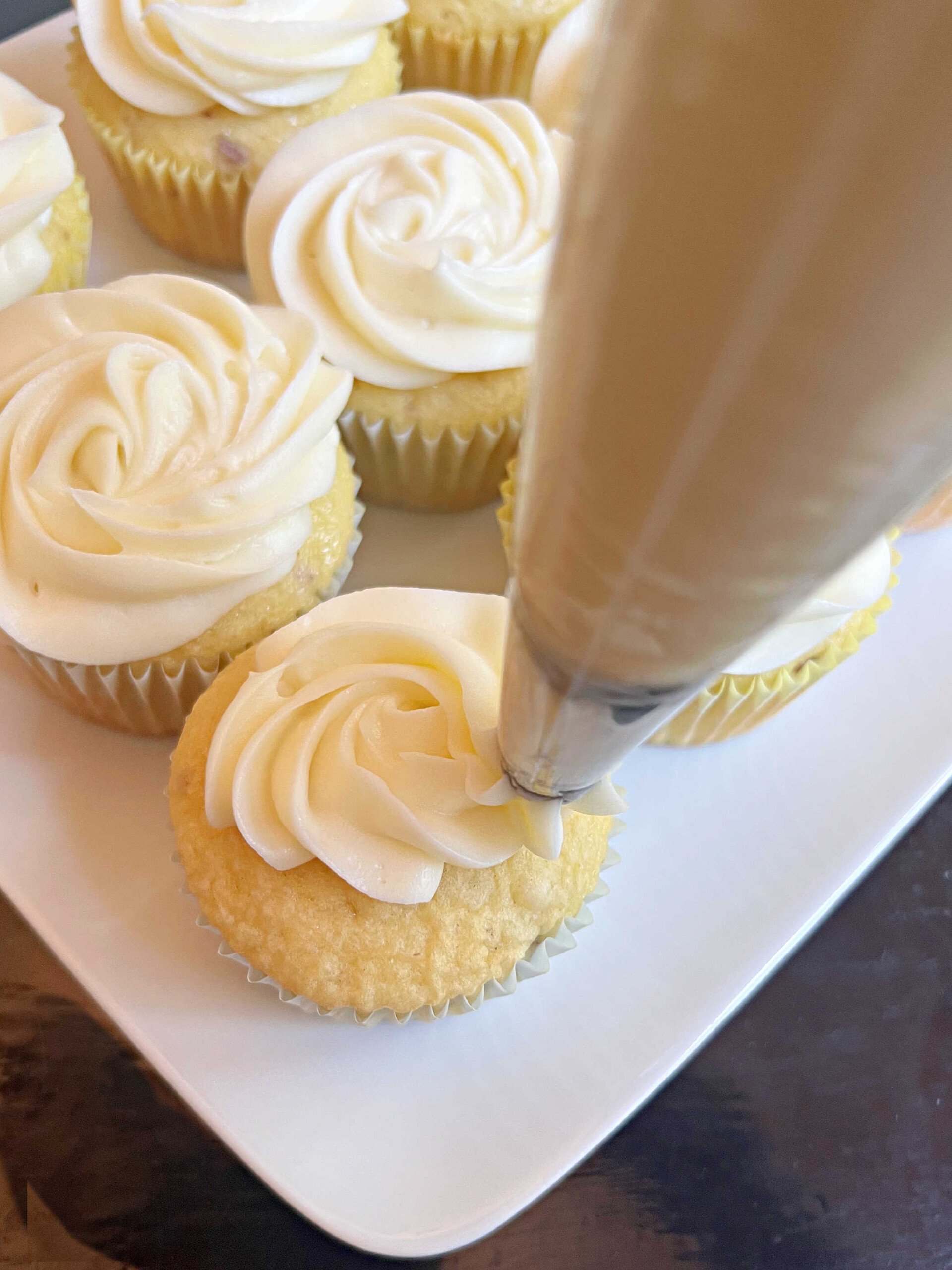 Decorating cupcakes with cream cheese frosting.