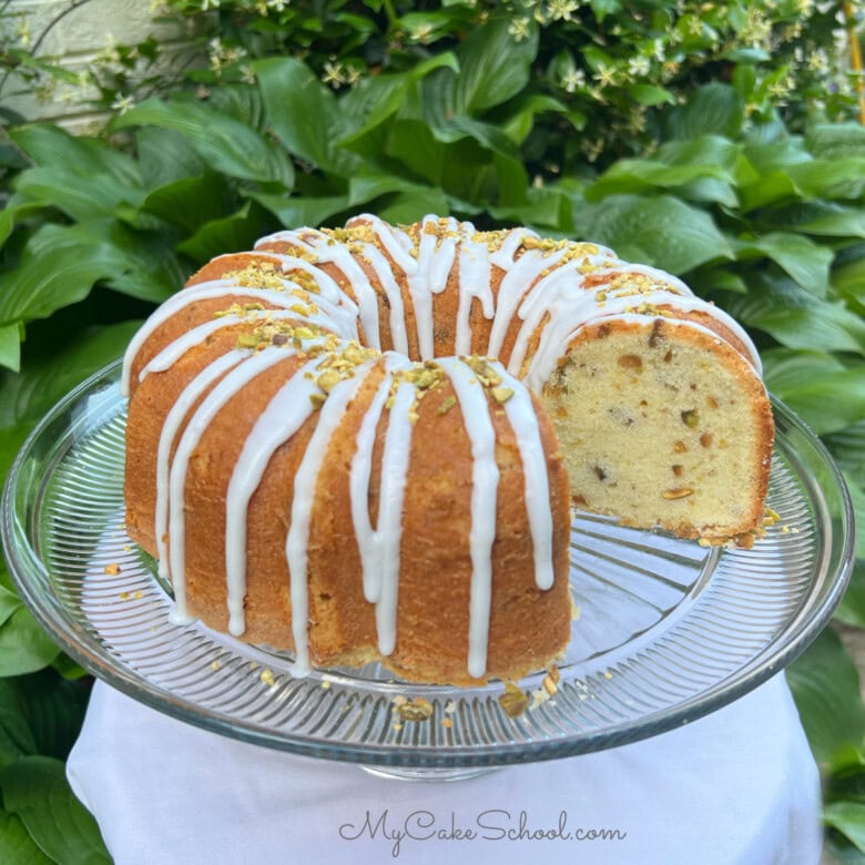 Pistachio Pound Cake, sliced, on a cake pedestal.