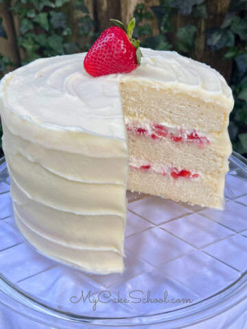 Strawberries and Cream Cake, sliced, on a cake pedestal.