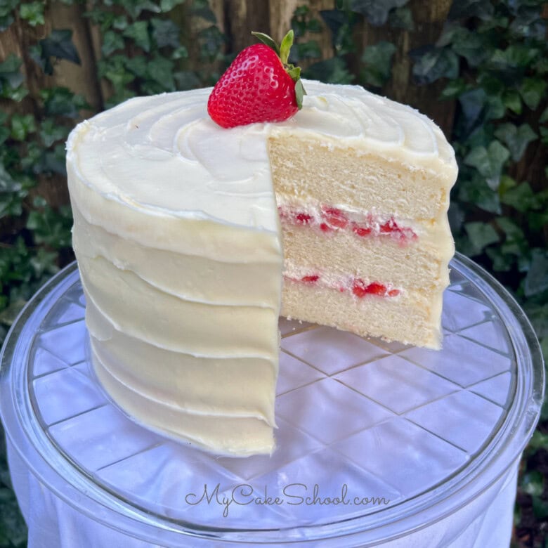 Strawberries and Cream Cake, sliced, on a cake pedestal.