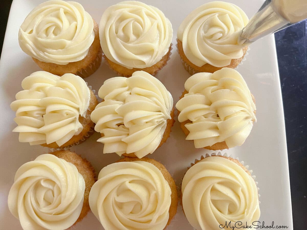 Decorating the Hummingbird Cupcakes with cream cheese frosting.