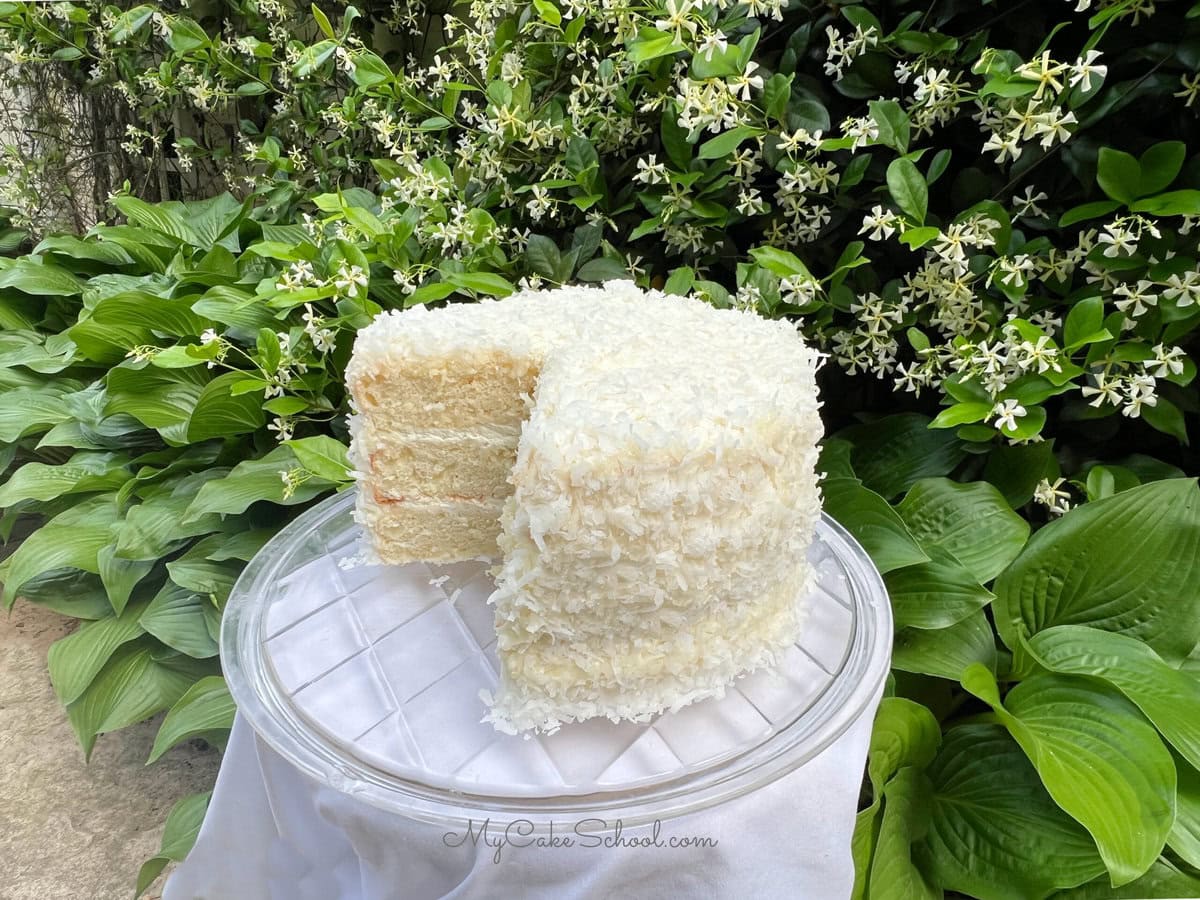 Easy Coconut Cake, sliced, on a cake plate.