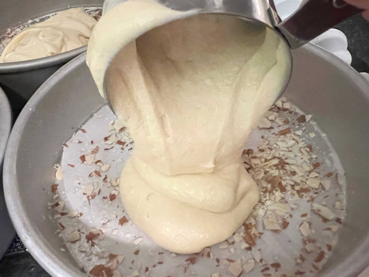 Filling the prepared pans with batter.
