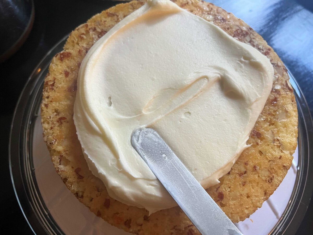 Spreading the cake layer with frosting.