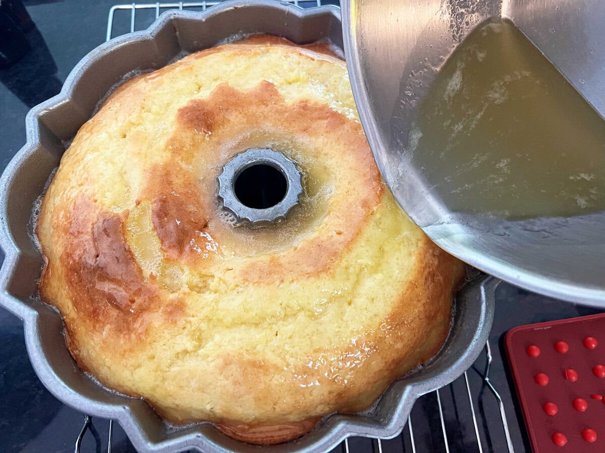 Pouring the butter rum glaze over the freshly baked cake while still in pan.