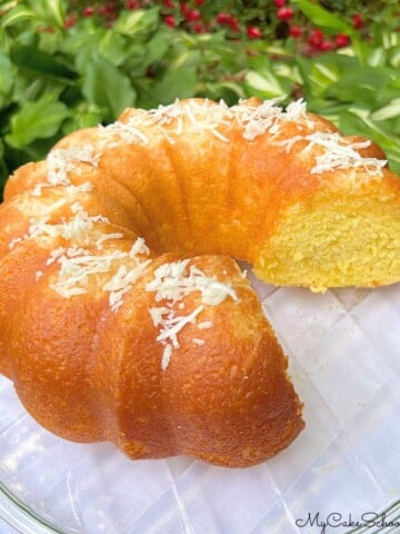 Coconut rum cake, sliced, on a cake pedestal.