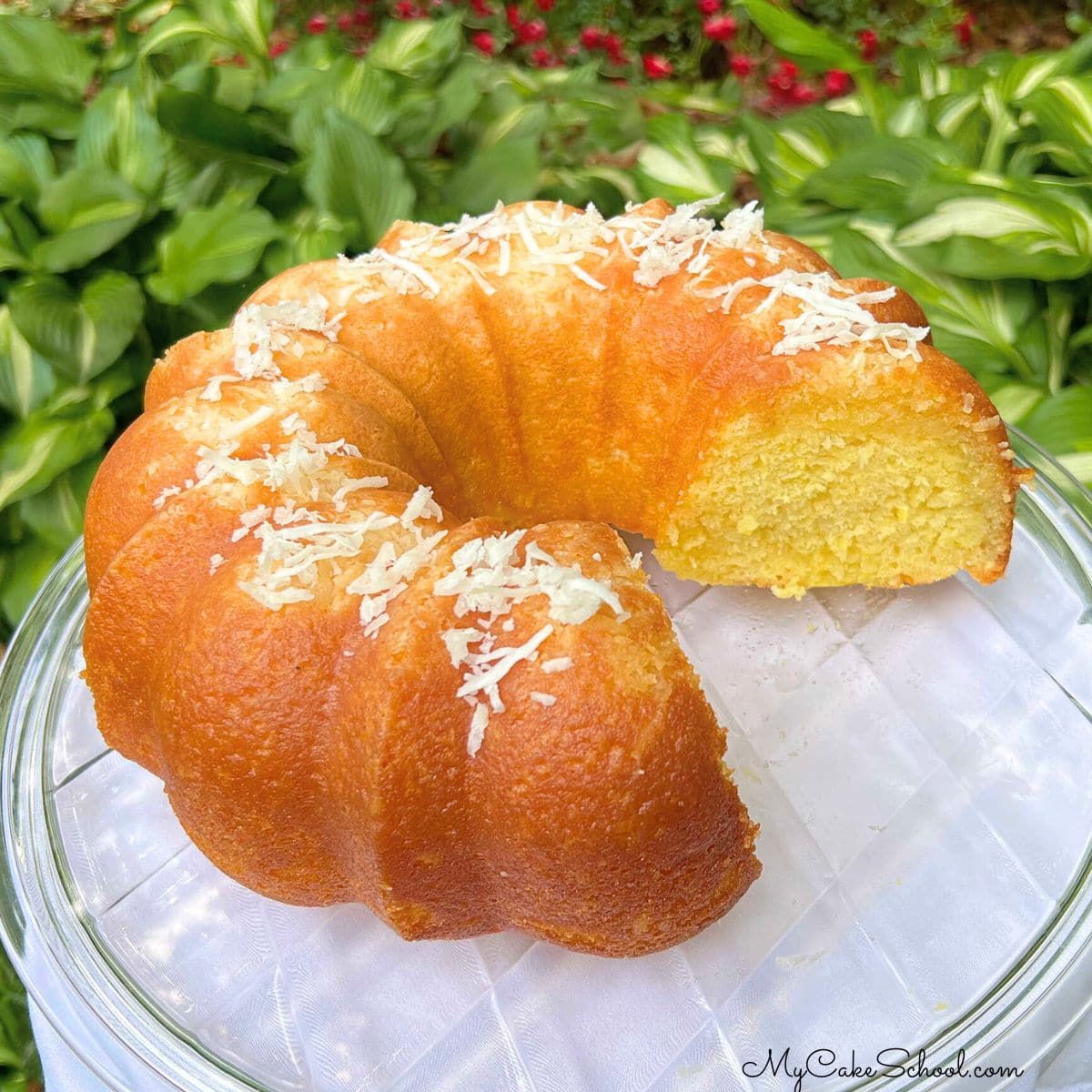 Coconut rum cake, sliced, on a cake pedestal.