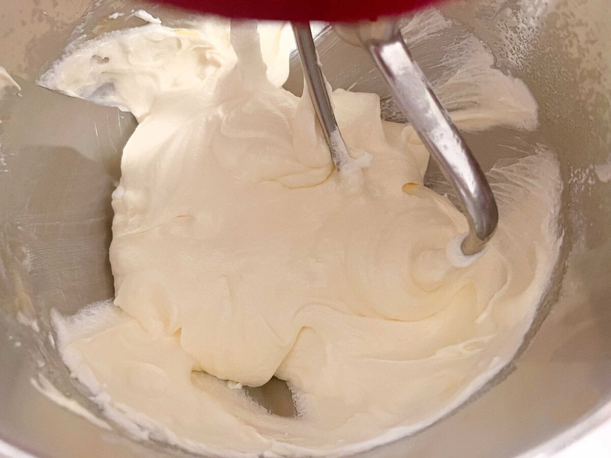 Mixing eggs into the batter.