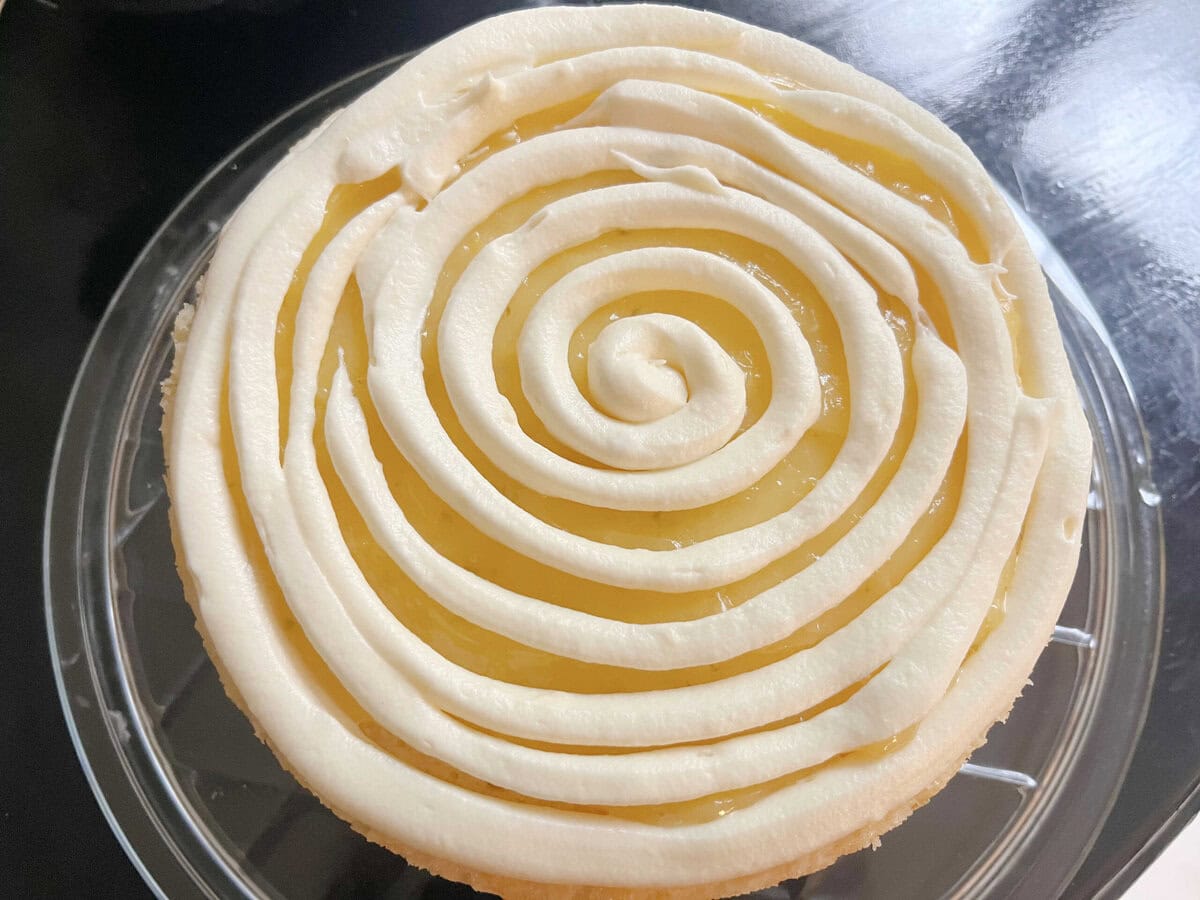 A spiral of frosting piped over the layer of lime curd.