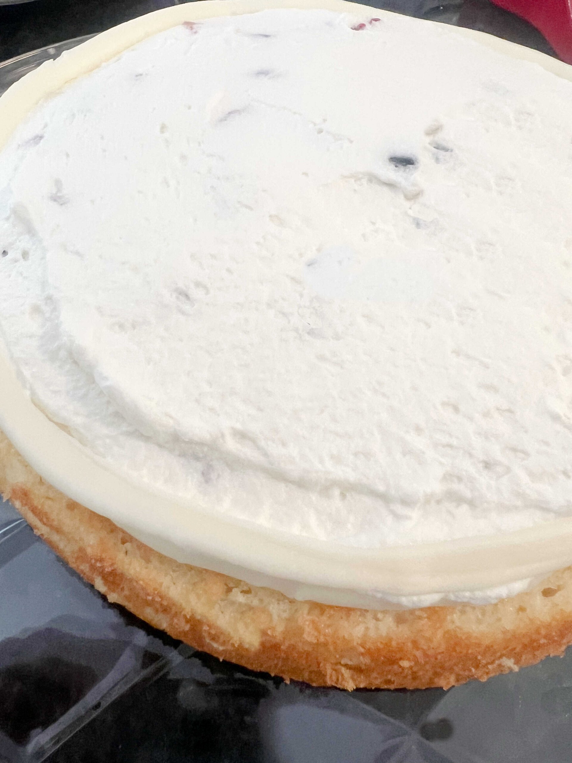 Spread whipped cream over the berries on the cake layer.
