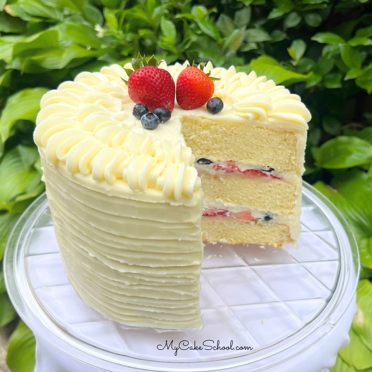 Berry Mascarpone Cake, sliced, on a cake plate.