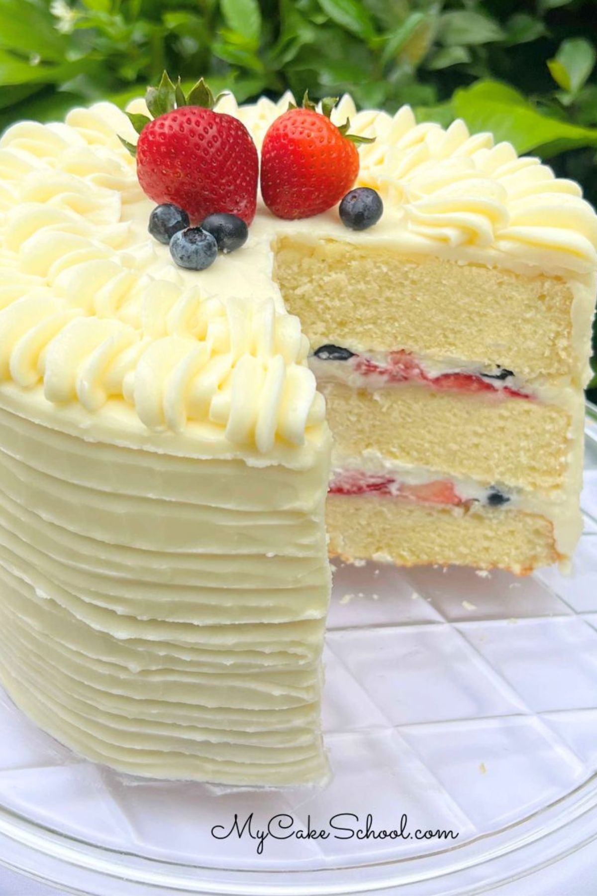 Berry Mascarpone Cake, sliced, on a cake pedestal.