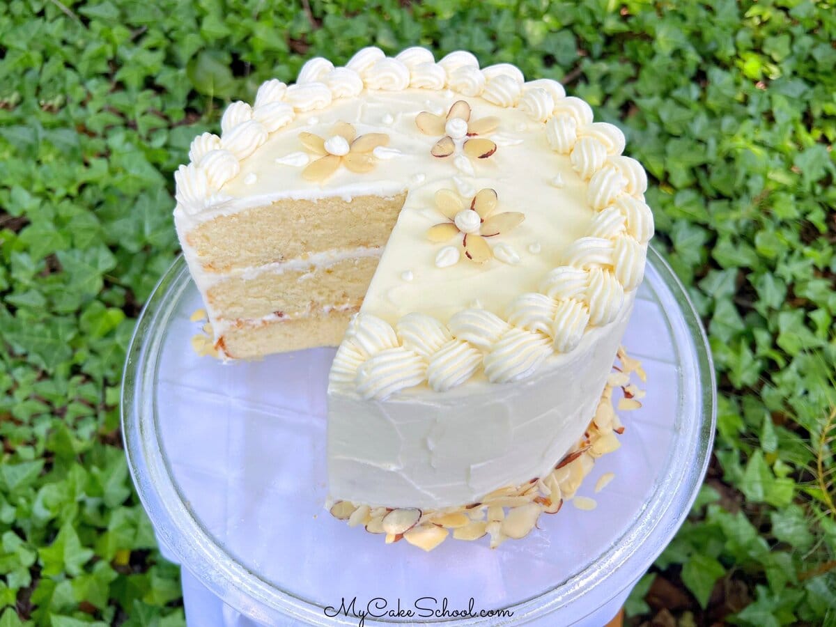 Easy Almond Cake, sliced, on a cake pedestal.