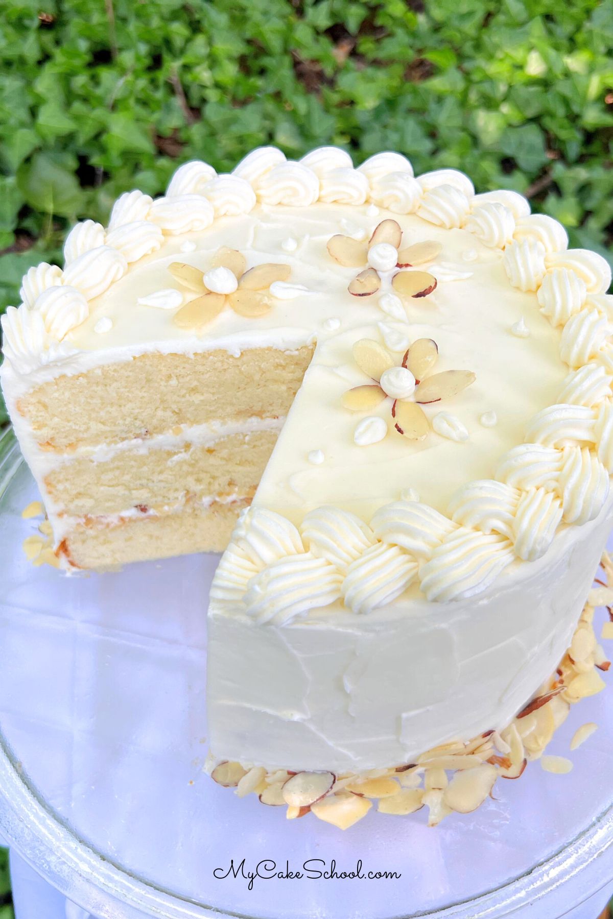 Easy Almond Cake, sliced, on a cake pedestal.