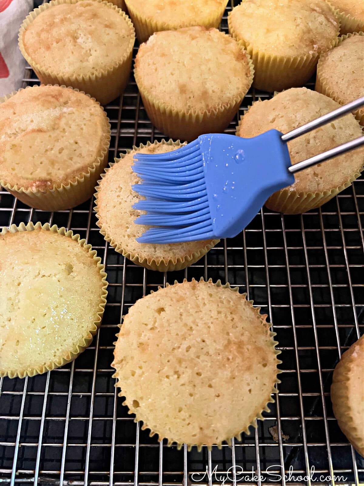 Brushing pineapple cupcakes with pineapple juice.