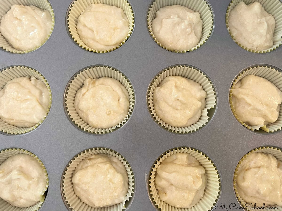 Pineapple Cupcake Batter in the paper liners in baking pan.