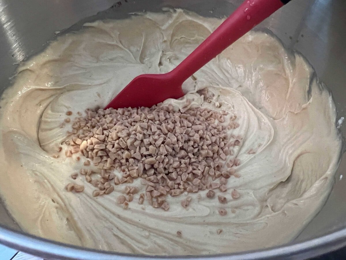 Stirring toffee bits into the cake batter.