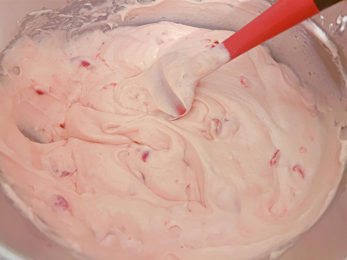 Stirring cherries into the Cherry Velvet Cake batter.