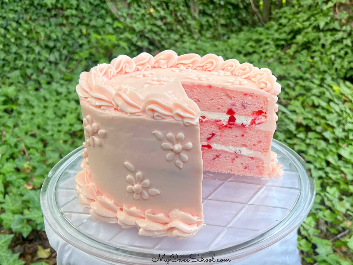Cherry Velvet Cake, sliced, on a pedestal.