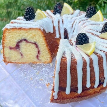 Lemon Blackberry Pound Cake, sliced, on a cake plate.