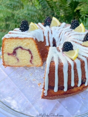 Lemon Blackberry Pound Cake, sliced, on a cake plate.