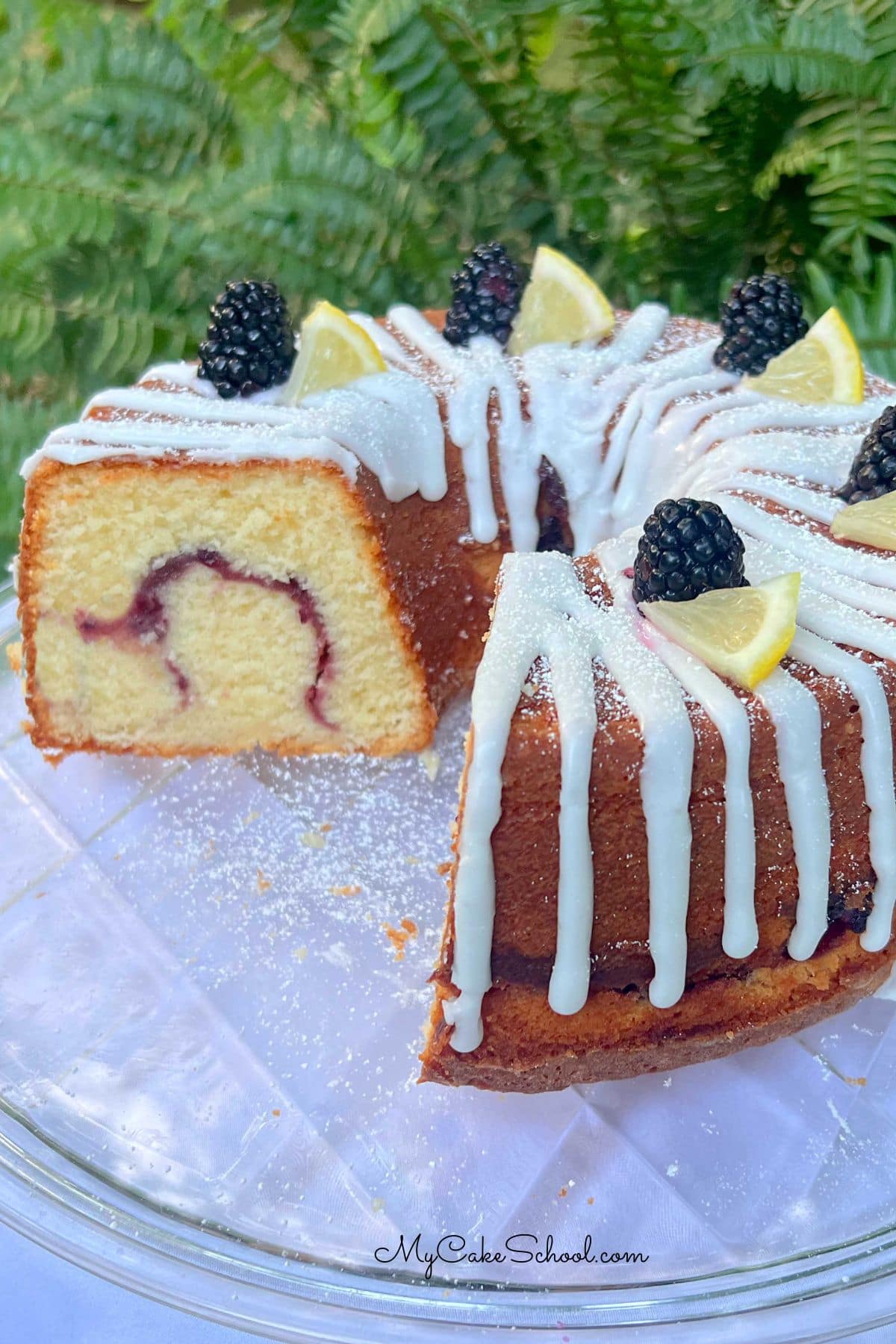 Lemon Blackberry Pound Cake, sliced, on a cake plate.