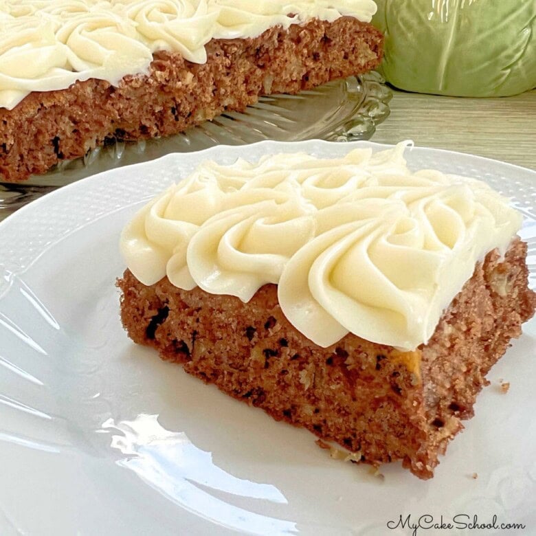 Slice of Apple Snack Cake on a plate, frosted with cream cheese frosting.