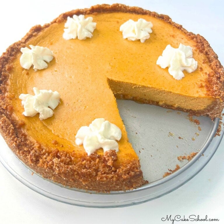 Pumpkin Cheesecake, sliced, on a cake plate.