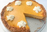 Pumpkin Cheesecake, sliced, on a cake platter.