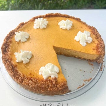 Pumpkin Cheesecake, sliced, on a cake platter.