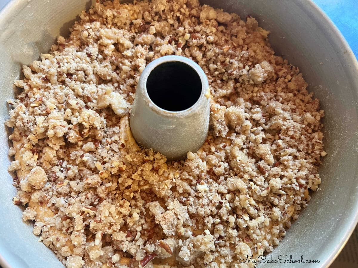 Streusel topping on top of cake batter, in bundt pan.
